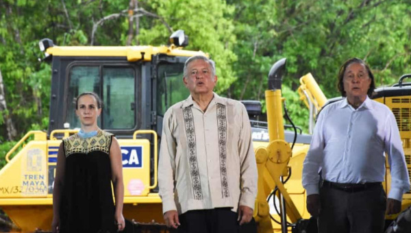 President AMLO with regional representatives in front of earth movers required to make way for the tracks